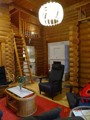 a living room with a staircase in a log cabin at Matila's Cottages in Sumiainen