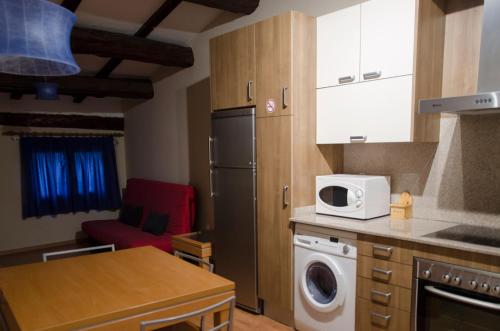 a kitchen with a refrigerator and a microwave at Apartaments El Jaç in Montblanc