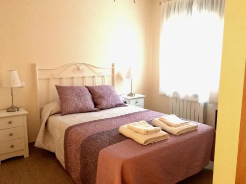 a bedroom with a bed with two towels on it at Apartamentos Rurales Flor De Lavanda in Brihuega