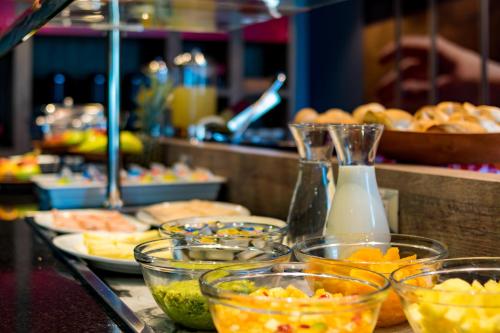 a buffet with many bowls of food on a table at ibis Puerto Montt in Puerto Montt