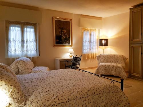 a bedroom with a bed and two chairs at Foresteria Borgo Delle Grazie in Curtatone