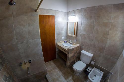 a bathroom with a toilet and a sink at El Refugio Casas de Campo in Villa General Belgrano