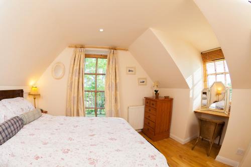 
A bed or beds in a room at Flowers of May Cottage
