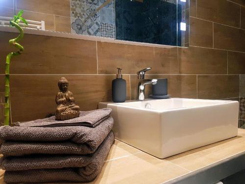 een badkamer met een grote witte wastafel en handdoeken bij Central Sweet Home in Saint-Gervais-les-Bains