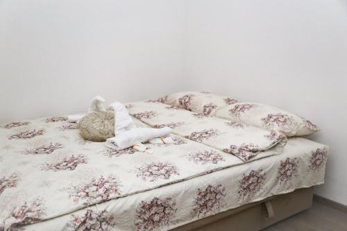 a bed with a floral bedspread and a stuffed animal on it at Comfort Inn Apartment 2 in Novi Pazar