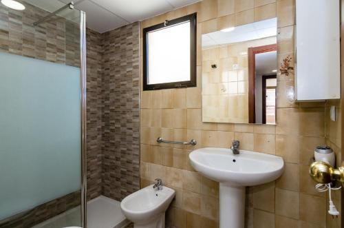 ein Badezimmer mit Waschbecken und Glasdusche in der Unterkunft CarlosV in Benidorm