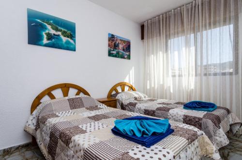 zwei Einzelbetten in einem Zimmer mit Fenster in der Unterkunft CarlosV in Benidorm