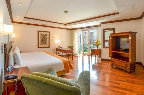 a hotel room with a bed and a television at Hotel Casa Veranda Guatemala in Guatemala