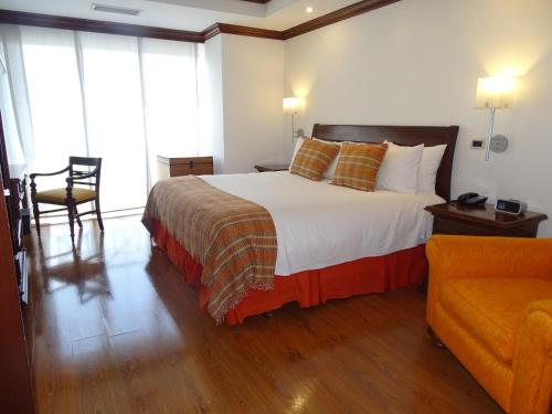 a bedroom with a bed and a chair and a couch at Hotel Casa Veranda Guatemala in Guatemala