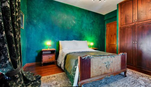 a bedroom with a bed and a green wall at Infinity Villa Ioannina in Ioannina