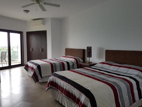 - une chambre avec 2 lits et des couvertures rayées dans l'établissement Makana Suite 6-11, à Tonsupa