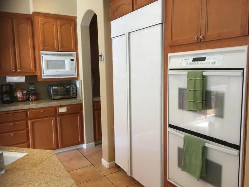 a kitchen with a white refrigerator and a microwave at Beautiful Home in Quiet Area in San Jose