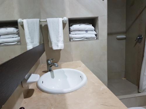 a bathroom with a sink and a shower and towels at Makana Suite 6-11 in Tonsupa