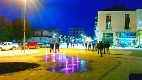 a group of people standing around a fountain at night at Funky Guest House & Adventures in Përmet