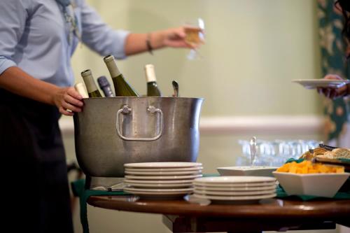 a person holding a glass of wine on a table at Kings Courtyard Inn in Charleston