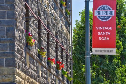 a sign on the side of a brick wall with flowers at Hotel La Rose in Santa Rosa