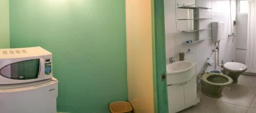 a small bathroom with a microwave and a toilet at Suites Atlantis in Punta del Este