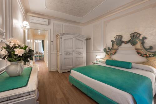 una camera da letto con un grande letto e un vaso di fiori di Guelphs Apartments a Verona