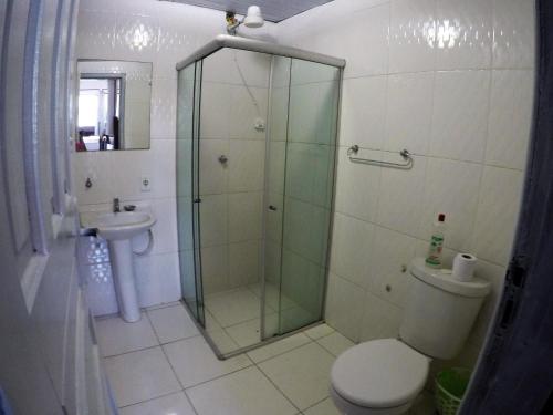 a bathroom with a shower and a toilet and a sink at Hostel Lobo Inn - Buzios in Búzios