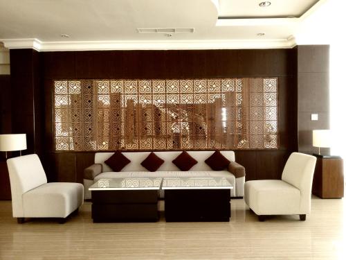 a living room with a couch and two chairs at Hotel Santika Luwuk - Sulawesi Tengah in Luwuk