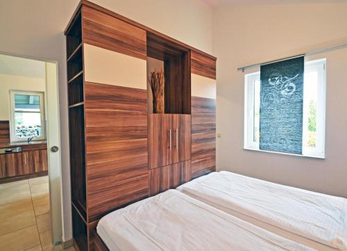 ツィノヴィッツにあるHaus Ostseekristall Wohnung Smaragdのベッドルーム(木製ヘッドボード、ベッド付)