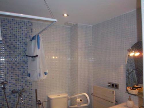 La salle de bains est pourvue de toilettes et d'un parasol. dans l'établissement Apartamentos Entrepalacios, à Avilés