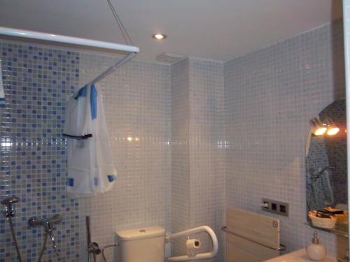 アビレスにあるApartamentos Entrepalaciosのトイレと傘付きのバスルーム
