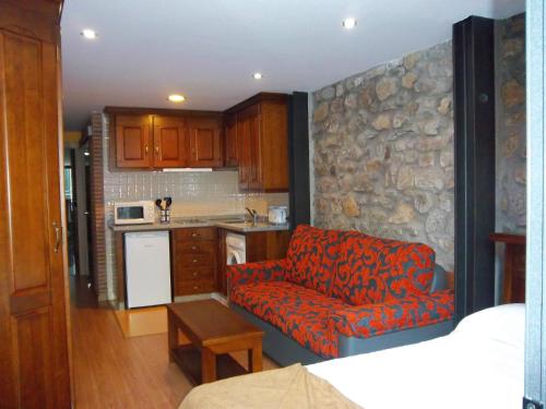 a living room with a couch and a kitchen at Apartamentos Entrepalacios in Avilés