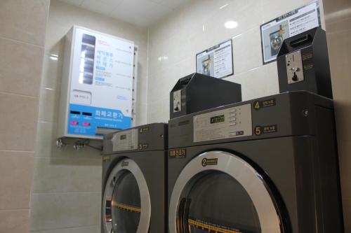 a washing machine and a dryer in a room at Geoje Artnouveau Suite Hotel in Geoje 