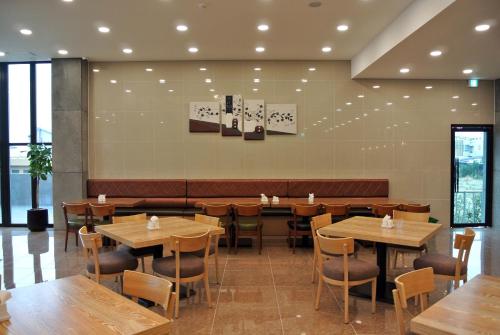 a dining room with wooden tables and chairs at Jeju Noblesse Hotel in Jeju