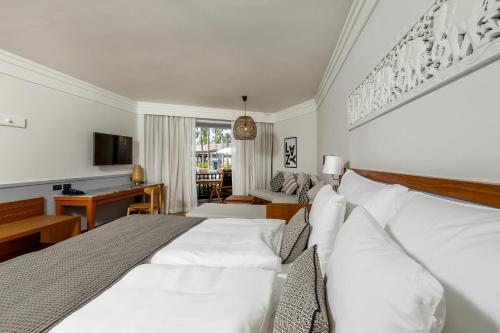 a bedroom with a large white bed and a desk at Sunwing Bangtao Beach in Bang Tao Beach