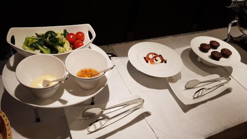 a table with plates of food and bowls of vegetables at Geoje Artnouveau Suite Hotel in Geoje 