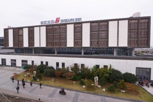 a building with people walking in front of it at Jinjiang Inn Suzhou Railway Station North Square in Suzhou