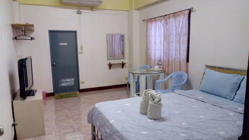 um quarto com uma cama, uma televisão e uma mesa em DD Mansion em Ban Talat Rangsit