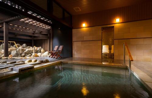 a swimming pool in a building with a pool at Kurotake in Achi