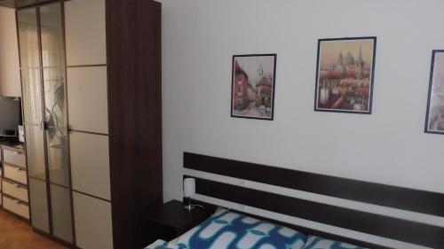 a bedroom with a bed and some pictures on the wall at Penzion U Žabáka in Mikulov