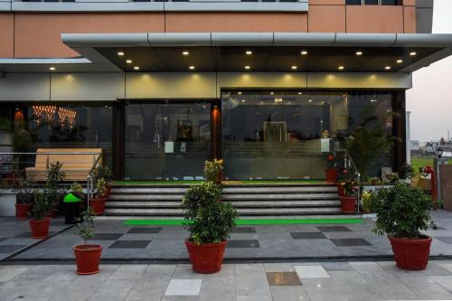 a building with stairs and potted plants in front of it at Hotel Shyam Palace in Bhuj