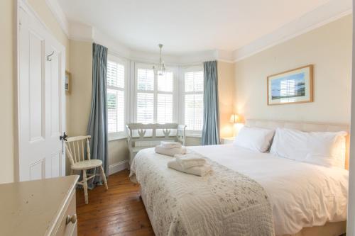 Un dormitorio con una gran cama blanca y una mesa en Lower Saltings, en Aldeburgh