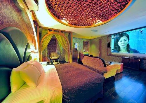 a bedroom with a large bed and a tv at Hakodate Motel in Kaohsiung