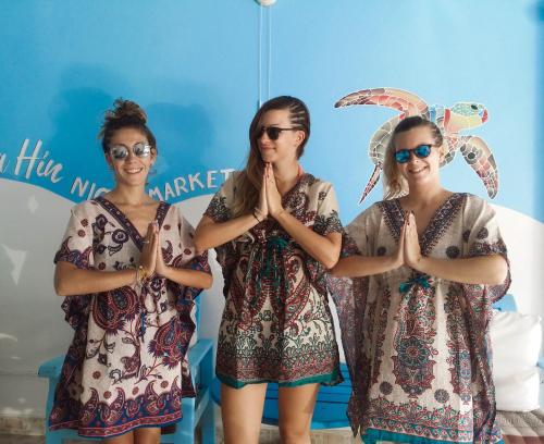 a group of three women standing in a room holding umbrellas at HuaHin Night Market Hostel in Hua Hin