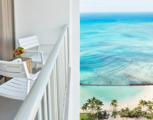 a room with a balcony with a view of the ocean at 'Alohilani Resort Waikiki Beach in Honolulu