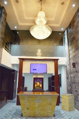 a large room with a podium with a chandelier at Malhar Grand in Jejūri