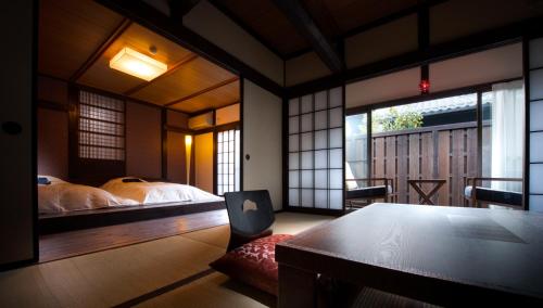 a bedroom with a table and a bed and a window at Kurotake in Achi