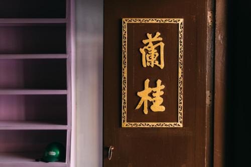 a wooden door with a sign on it at Aekkeko hostel in Phuket Town