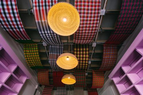 an overhead view of colorful ties hanging from a ceiling at Aekkeko hostel in Phuket Town