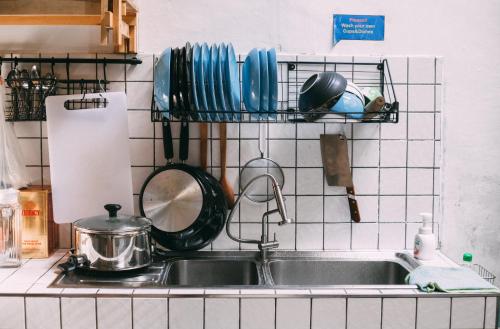 a kitchen sink with utensils on a wall at Aekkeko hostel in Phuket Town