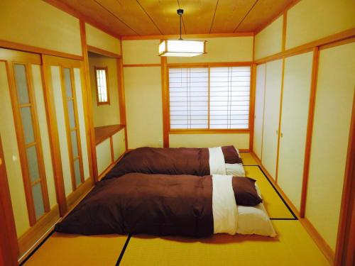 um quarto com uma cama no canto de um quarto em Utatei Villa em Takayama