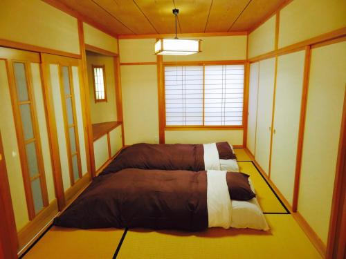 une chambre avec un lit dans le coin d'une pièce dans l'établissement Utatei Villa, à Takayama