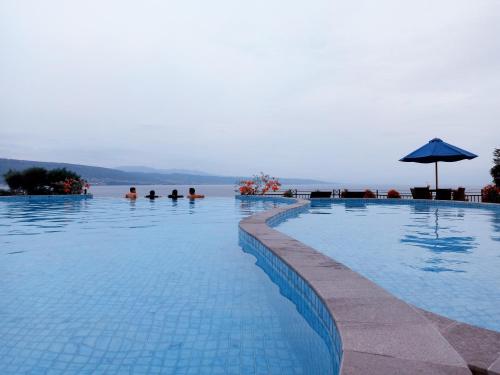 a large swimming pool with a view of the water at Hotel Santika Luwuk - Sulawesi Tengah in Luwuk