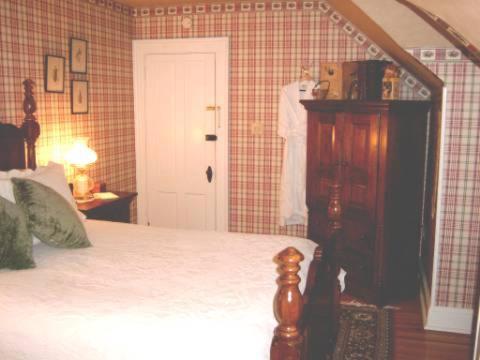 a bedroom with a bed and a cabinet and a door at Brookview Manor Inn in Canadensis